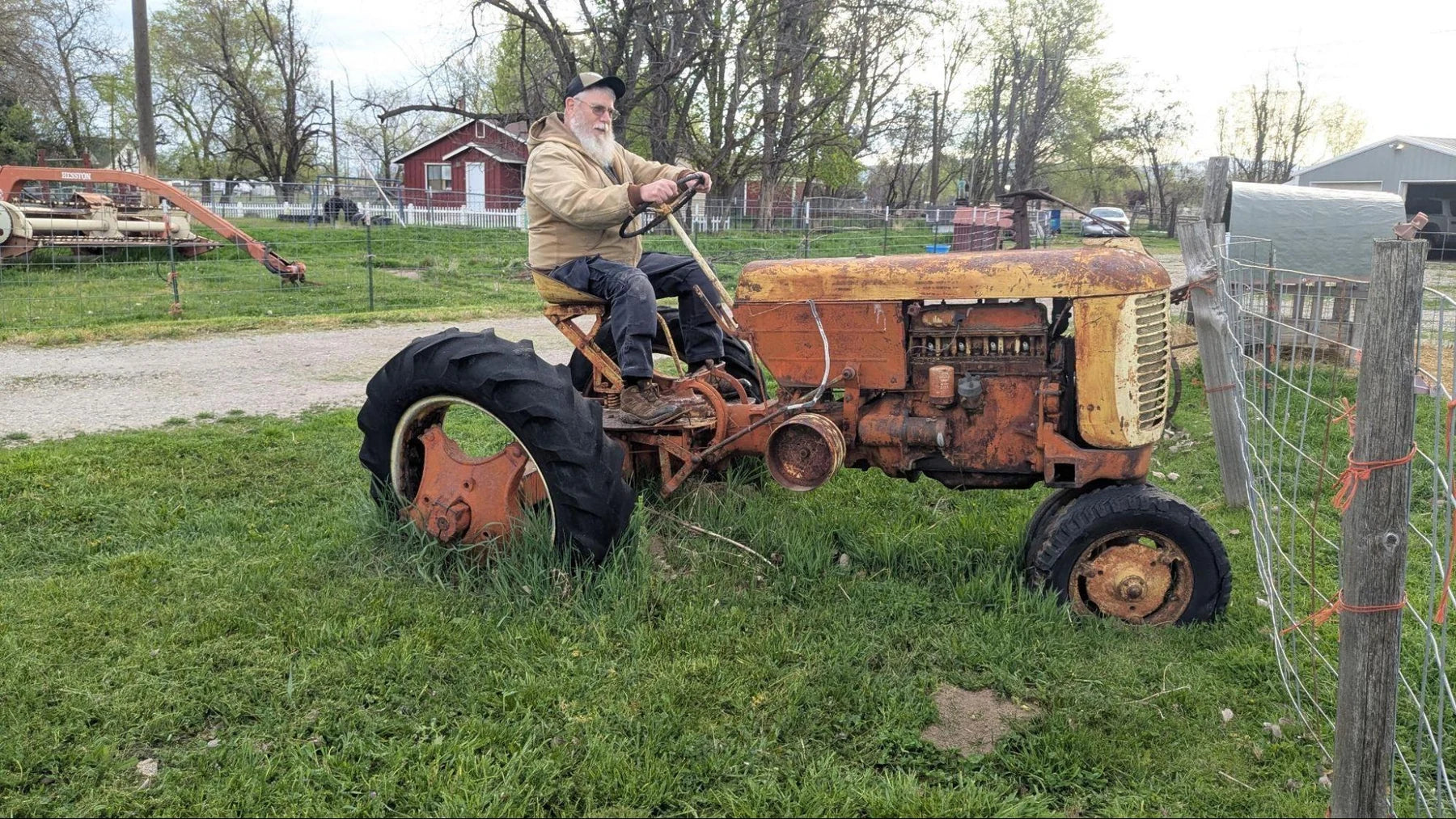 Brian Andersen seated on an orange tractor at the family farm