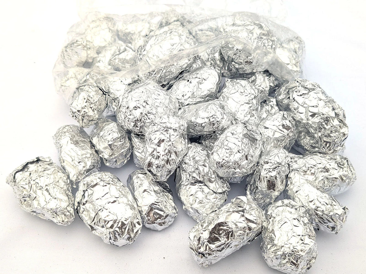 Individually foil-wrapped barn owl pellets spilling from an open bag