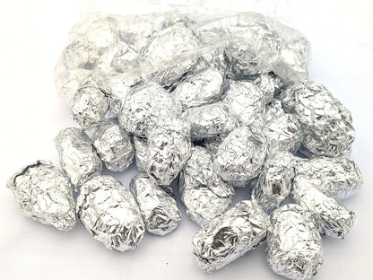 Individually foil-wrapped barn owl pellets spilling from an open bag
